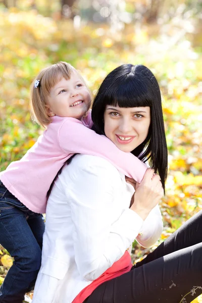 Beautiful young mother and her daughter on the autumv forest — Stock Photo, Image