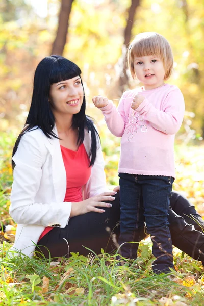 Schöne junge Mutter und ihre Tochter im herbstlichen Wald — Stockfoto