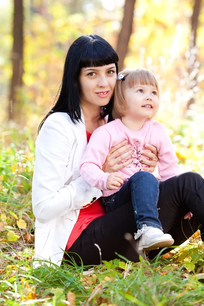 Bela jovem mãe e sua filha na floresta de outono — Fotografia de Stock