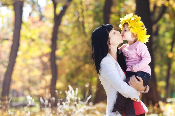 Krásná mladá matka drží její dcera v věnec javor — Stock fotografie