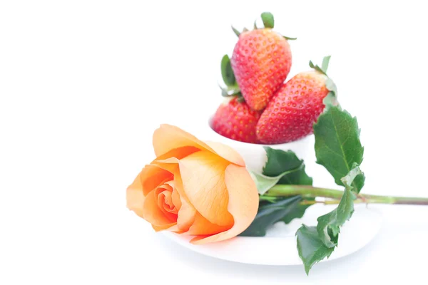 Piękny pomarańczowy rose, truskawki i kubek na białym tle — Zdjęcie stockowe