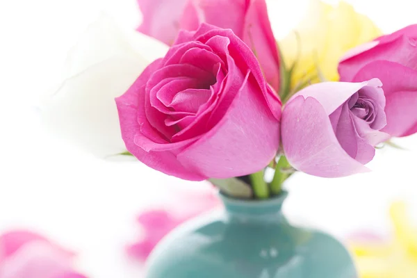 Strauß bunter Rosen in Vase und Blütenblättern — Stockfoto