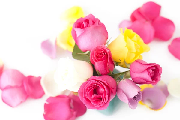 Bouquet of colorful roses in vase and petals — Stock Photo, Image