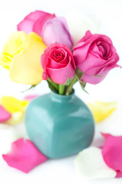 Bouquet of colorful roses in vase and petals — Stock Photo, Image