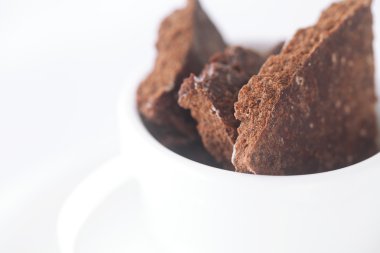 Beyaz fincan ile fincan tabağı ve çikolata