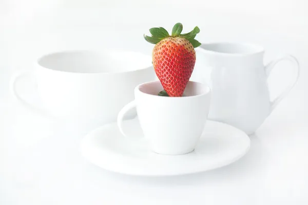 White cup with saucer, milk jug and strawberry — Stock Photo, Image
