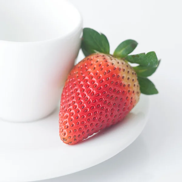 White cup with saucer and strawberries — Stock Photo, Image