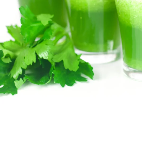 Celery and three glasses with celery juice isolated on white — Stock Photo, Image