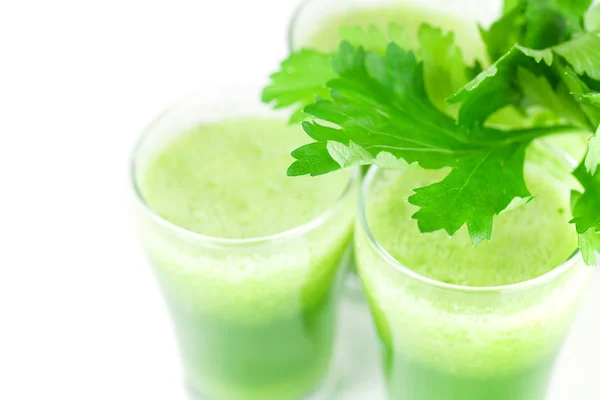 Celery and three glasses with celery juice isolated on white — Stock Photo, Image