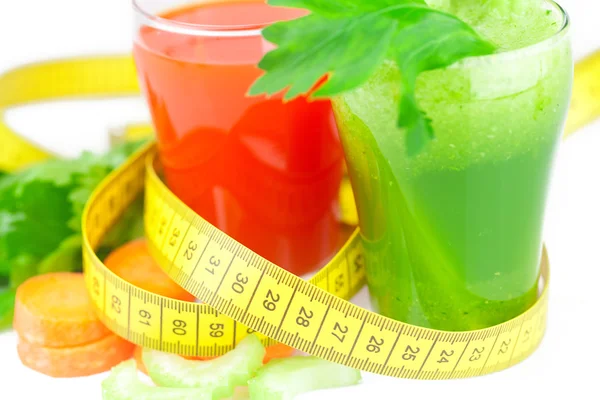 Measuring tape, glass of celery juice and glass of carrot juice — Stock Photo, Image