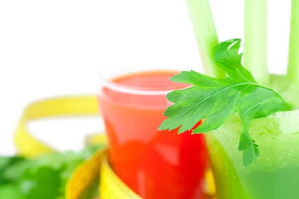 Cinta métrica, vaso de jugo de apio y vaso de jugo de zanahoria — Foto de Stock