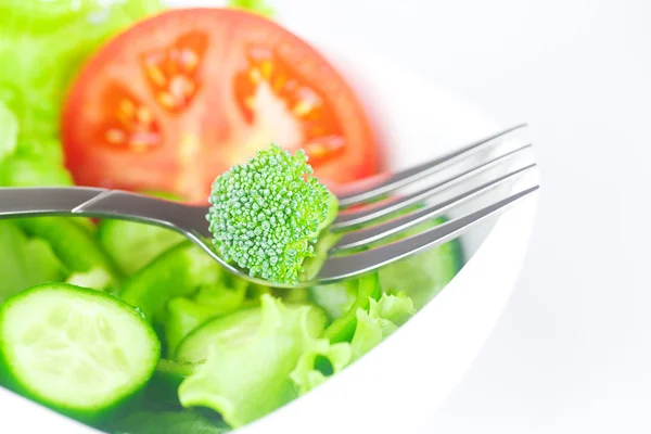 Gabel, Brokkoli, Salat, Tomaten, Gurken und Paprika in einer Schüssel iso — Stockfoto