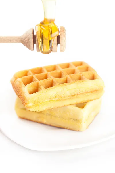 Waffles belgas em um prato, pau para mel e mel isolado o — Fotografia de Stock