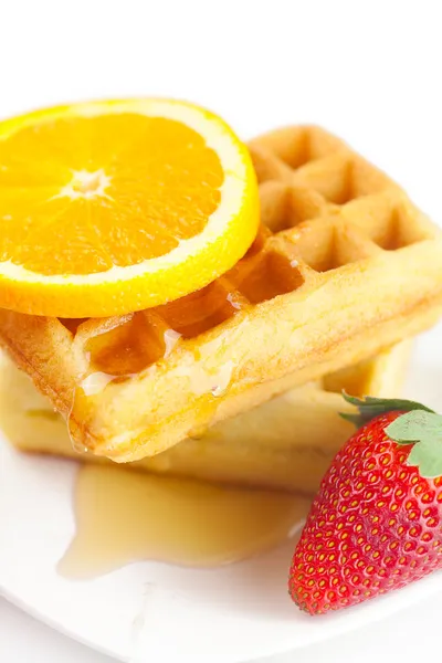 Belgische Waffeln, Honig, Orangen und Erdbeeren auf einem Teller — Stockfoto