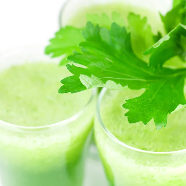 Celery and three glasses with celery juice isolated on white — Stock Photo, Image