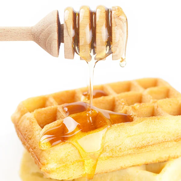 Waffles belgas em um prato, pau para mel e mel isolado o — Fotografia de Stock