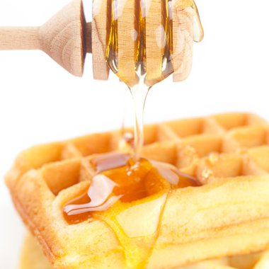 Belçika waffle bir tabakta bal ve bal izole o sopa