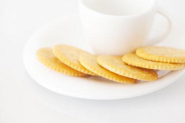 Beyaz fincan ile fincan tabağı ve kraker