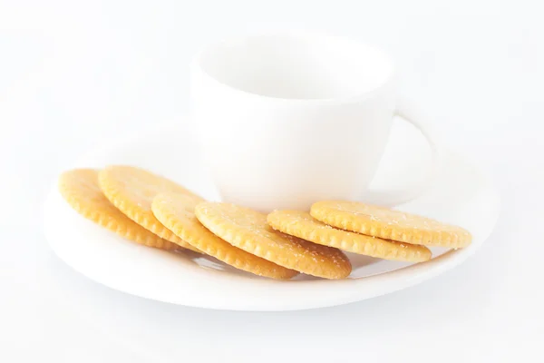 Taza blanca con platillo y galletas saladas —  Fotos de Stock
