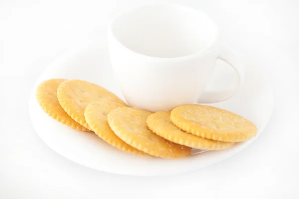 Taza blanca con platillo y galletas saladas — Foto de Stock