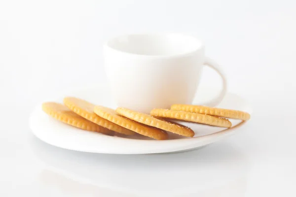 Taza blanca con platillo y galletas saladas —  Fotos de Stock