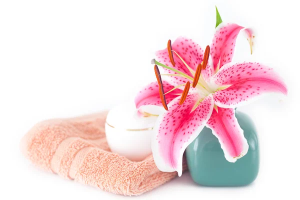 Belo lírio em um vaso, toalha e recipientes cosméticos — Fotografia de Stock