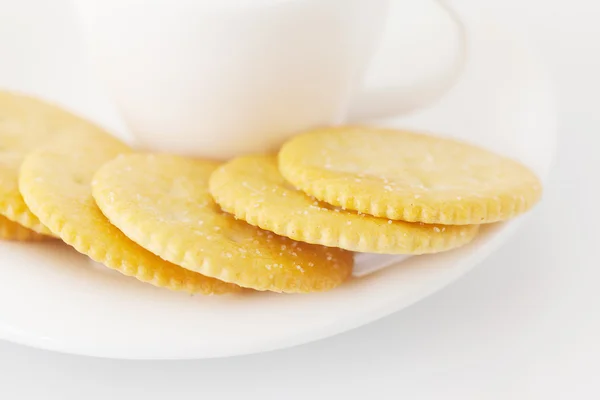 Taza blanca con platillo y galletas saladas — Foto de Stock