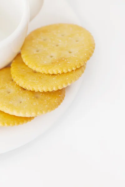 Taza blanca con platillo y galletas saladas — Foto de Stock