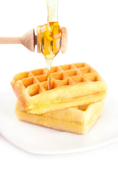 Belgian waffles on a plate, stick for honey and honey isolated o — Stock Photo, Image