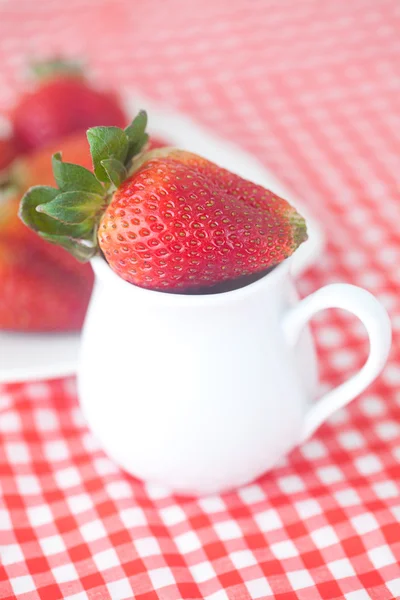 Strawberries in jar on checkered fabric — Stock Photo, Image