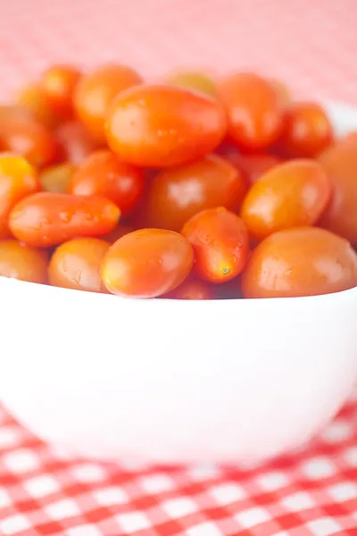 Tomates cherry en tazón sobre tela a cuadros —  Fotos de Stock