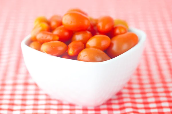 Pomodoro ciliegia in ciotola su tessuto a quadretti — Foto Stock