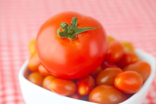 Wiśniowe pomidory i pomidory w misce na kratkę tkaniny — Zdjęcie stockowe