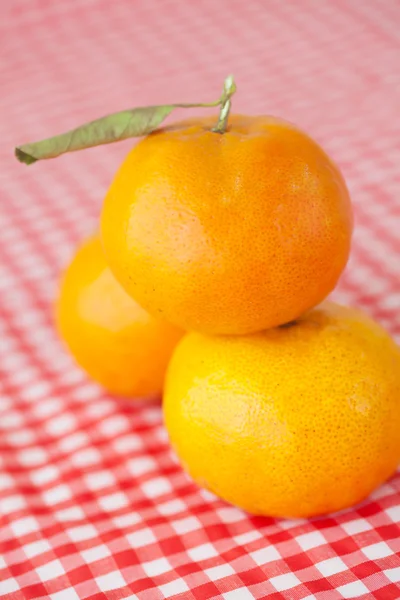 Tangerine on checkered fabric — Stock Photo, Image