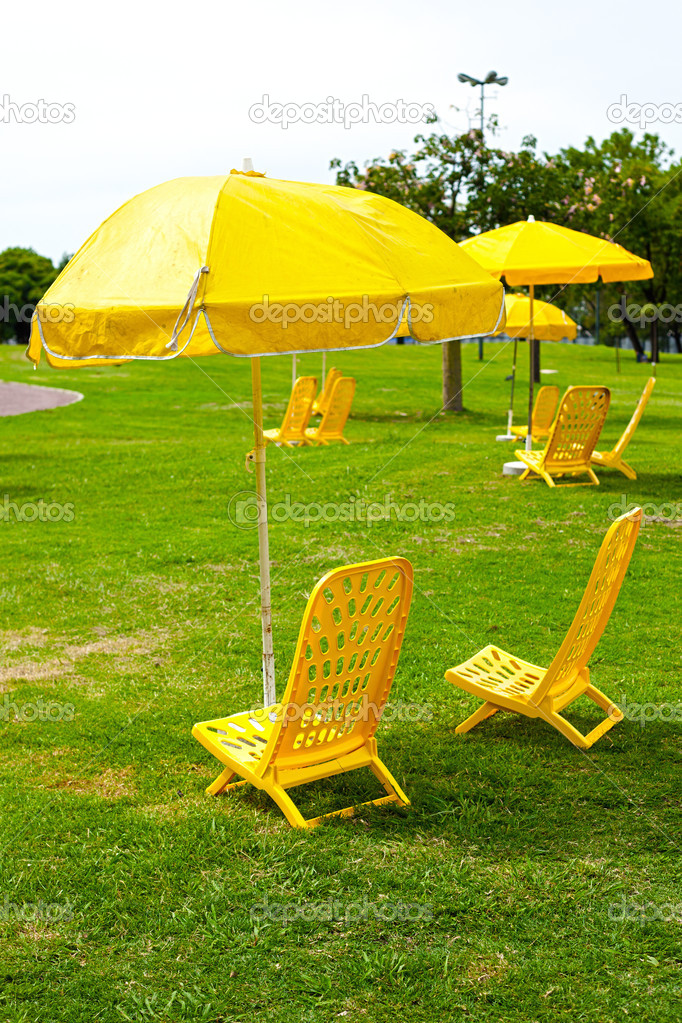 yellow umbrellas and loungers standing on the grass
