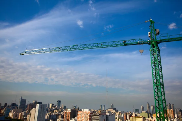 Tower crane above the city on a background of blue sky — Stock Photo, Image