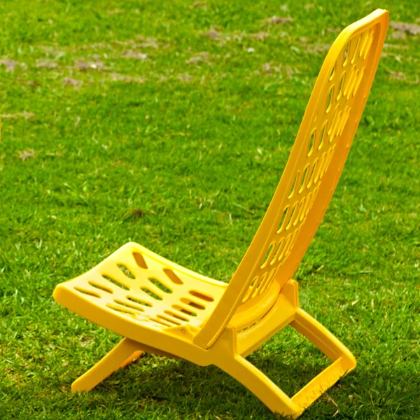 Tumbona amarilla de pie sobre la hierba —  Fotos de Stock
