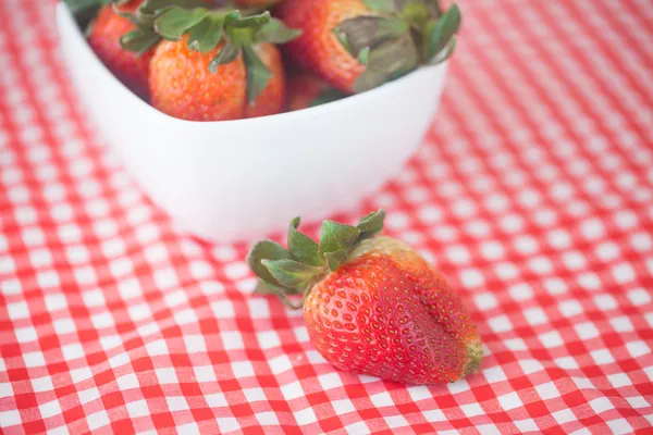 Strawberries in bowl on checkered fabric — Stock Photo, Image