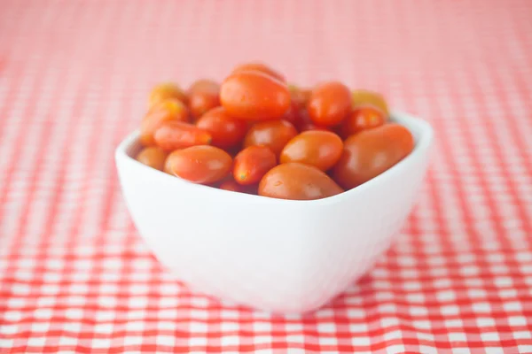 Cherry tomatos in bowl on checkered fabric — Stok fotoğraf
