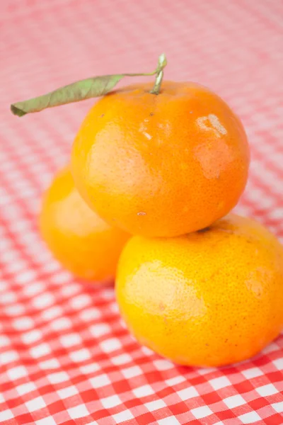 Tangerine on checkered fabric — Stock Photo, Image
