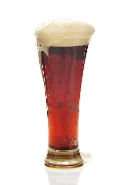 Ciemne piwo z pianką w wysokiej szklance na białym tle — Zdjęcie stockowe