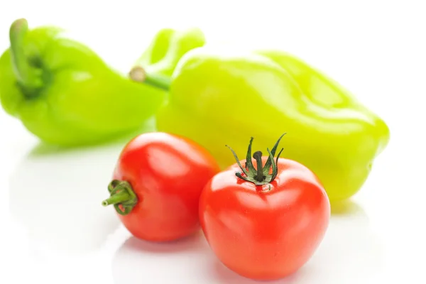 Tomates e pimentas verdes isolados em branco — Fotografia de Stock