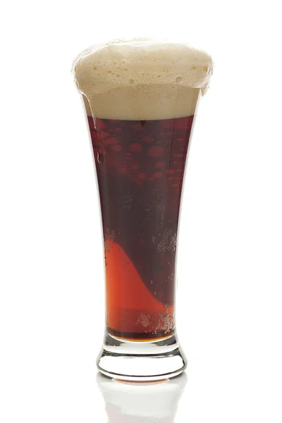 Mørk øl med skummet i et højt glas isoleret på hvid - Stock-foto