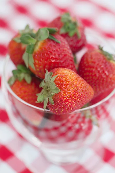 Strawberry in a glass bowl on checkered fabric — Stockfoto