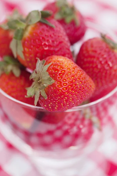 Strawberry and cherry in a glass bowl on checkered fabric — Stock Photo, Image