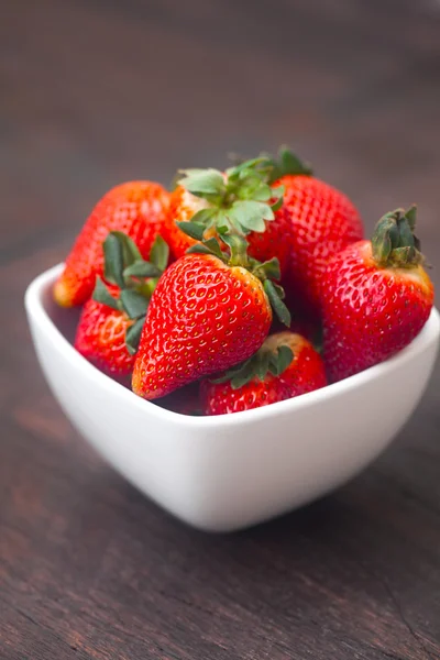 Rote saftige Erdbeere in einer Schüssel auf einer Holzoberfläche Stockfoto