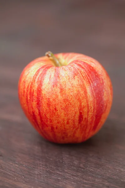 Saftiger Apfel auf einer Holzoberfläche Stockbild