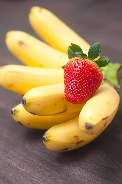 Banda banány a jahody na dřevěný podklad Royalty Free Stock Obrázky