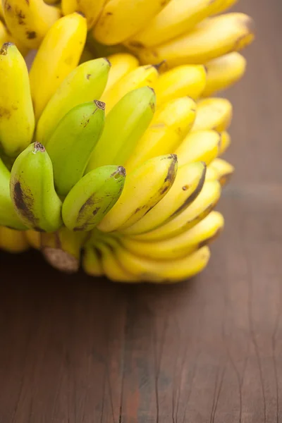 Racimo de plátanos sobre una superficie de madera —  Fotos de Stock