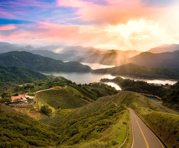 Pôr do sol bonito com estrada verde — Fotografia de Stock